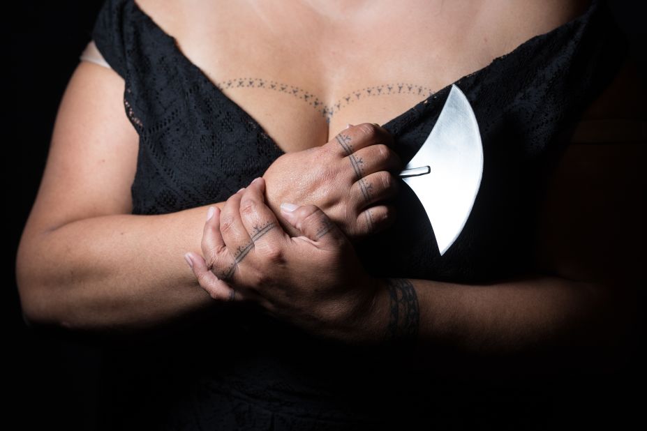 <strong>Poised with an ulu: </strong>Cora DeVos holds a traditional Inuit knife and shows off the traditional Inuit tattoos she has on her chest, wrists and fingers.