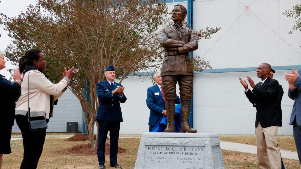 Harriett Bullard White, far left, and William Bullard, far right,Harr join in applause after the statue of Eugene Bullard was unveiled Wednesday at the Museum of Aviation near Robins Air Force Base in Georgia.