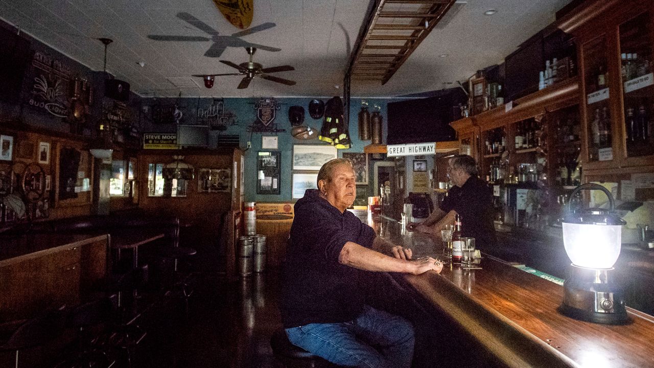Joseph Pokorski drinks a beer at the Town Square as downtown Sonoma, California, remains without power on Wednesday.