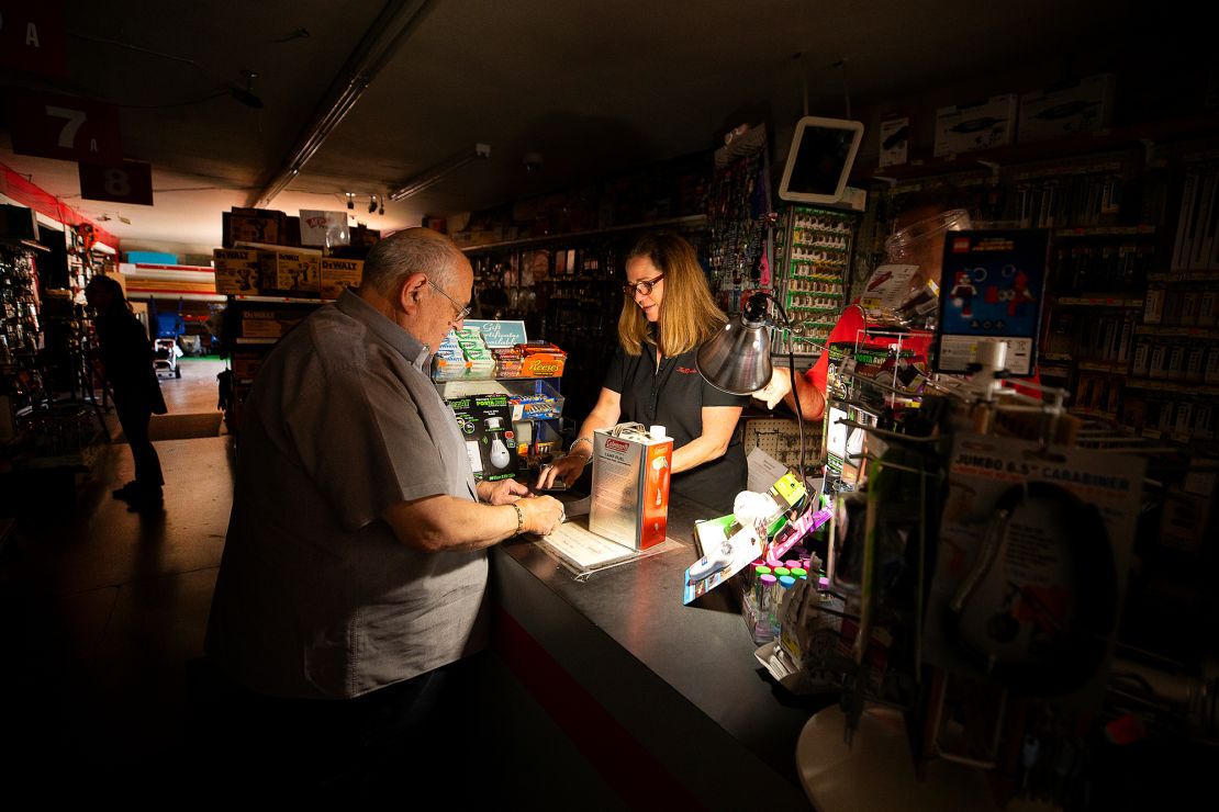 Tom Hyde, left, buys a can of fuel for his camp stove at a hardware store in preparation for a power outage.