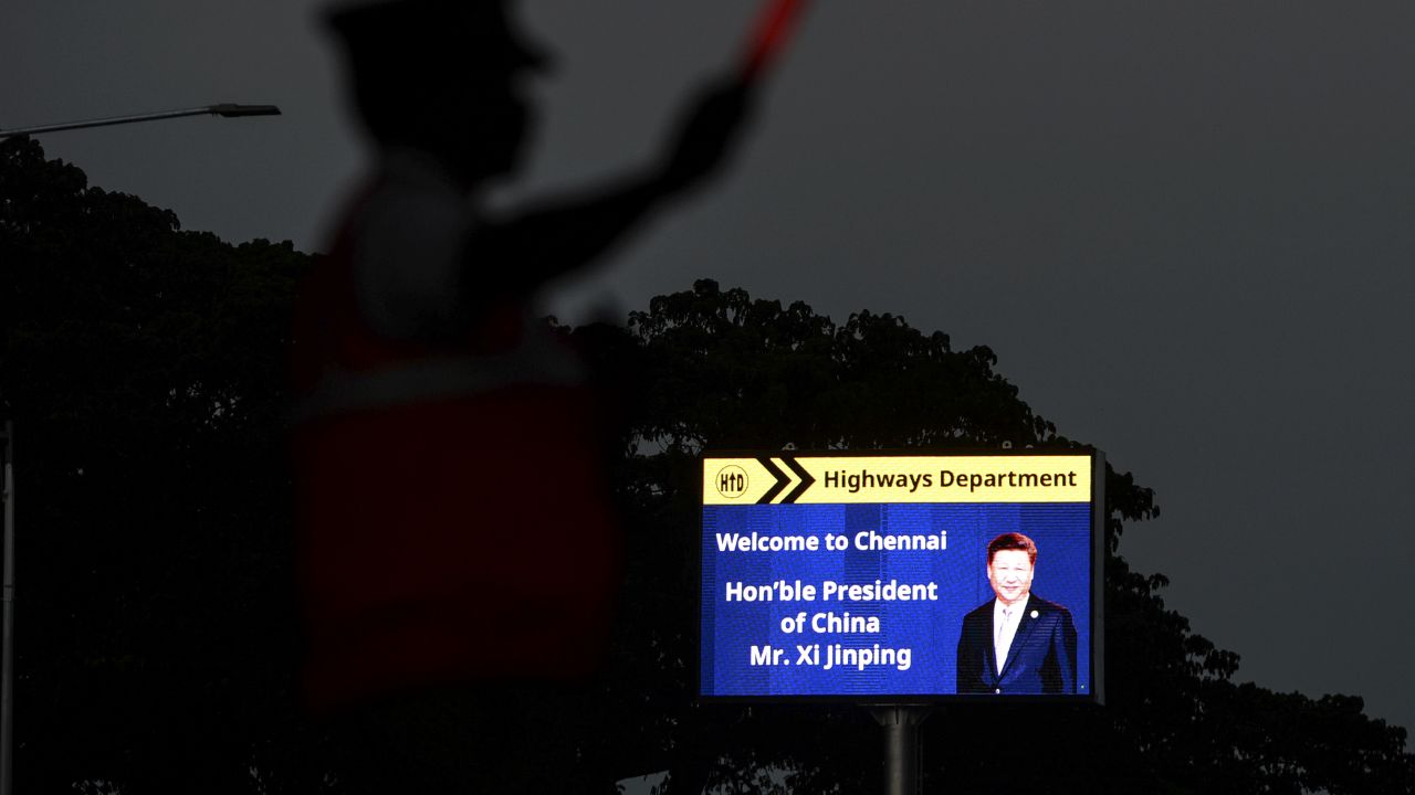 A traffic policeman stands beside a welcoming board for China's President Xi Jinping in Chennai on October 9, 2019, ahead of a summit with his Indian counterpart Narendra Modi held at the World Heritage Site of Mahabalipuram from October 11 to 13 in Tamil Nadu state.