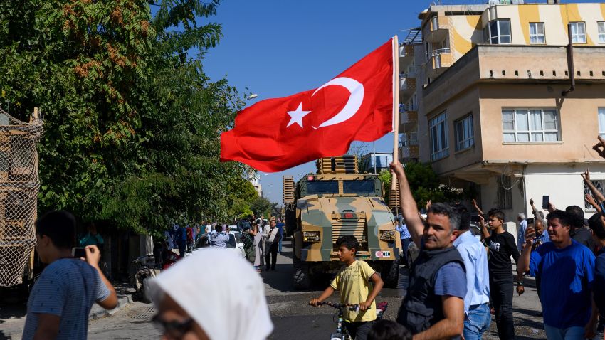 TOPSHOT - A man waves a Turkish flag as Turkey-backed Syrian opposition fighters going to Tel Abyad from Turkish gate towards Syria in Akcakale in Sanliurfa province on October 10, 2019. - Turkey has launched a broad assault on Kurdish-controlled areas in northeastern Syria, with intensive bombardment followed by a ground offensive made possible by the withdrawal of US troops. (Photo by BULENT KILIC / AFP) (Photo by BULENT KILIC/AFP via Getty Images)