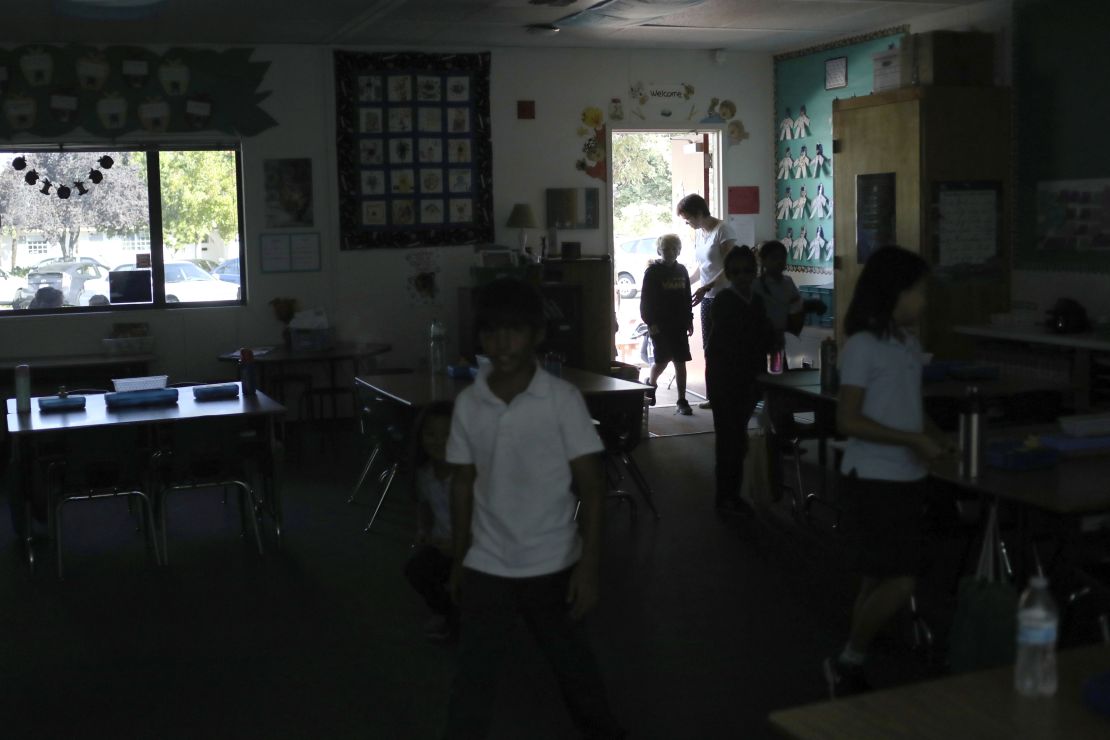 Students walk back into  class after a recess at a school in San Jose, California. They relied on sunlight after a Pacific Gas & Electric power shutdown turned out the lights. 