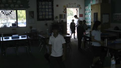 Students walk back into  class after a recess at a school in San Jose, California. They relied on sunlight after a Pacific Gas & Electric power shutdown turned out the lights. 