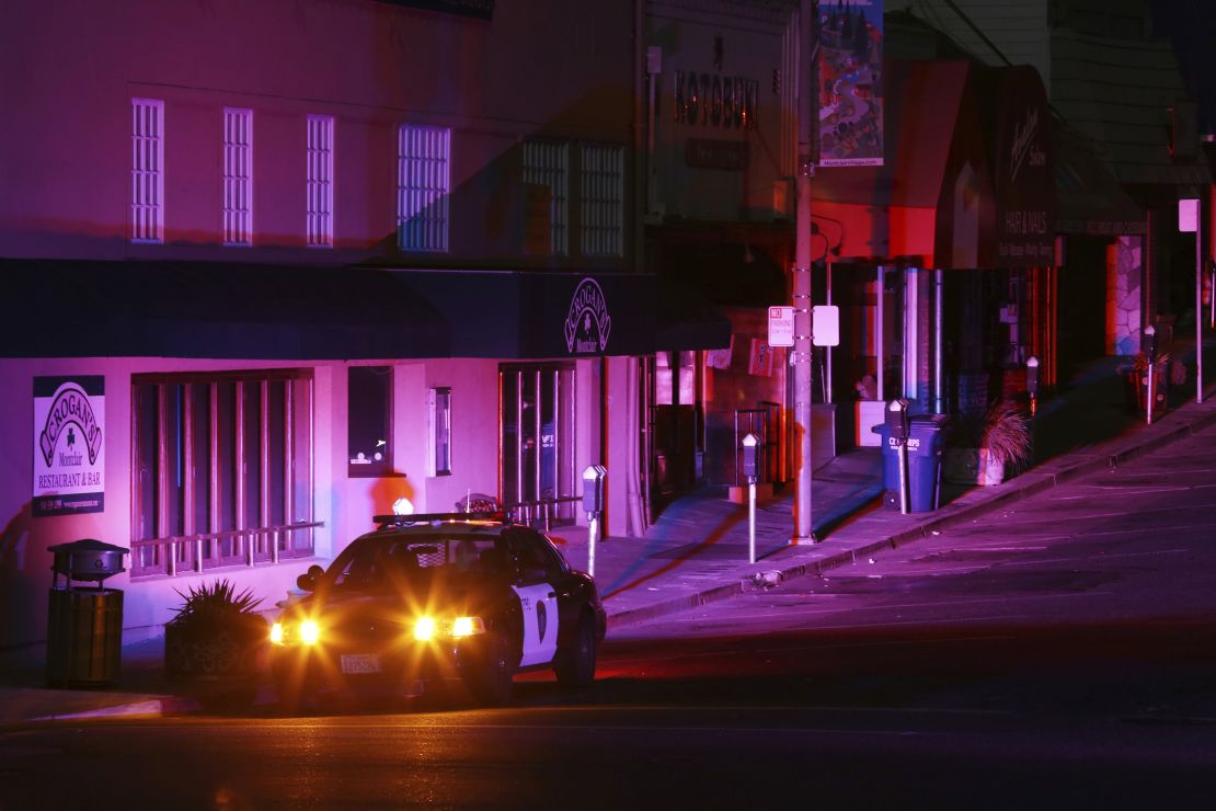 Police officers patrol a street during a power outage in Oakland, California.