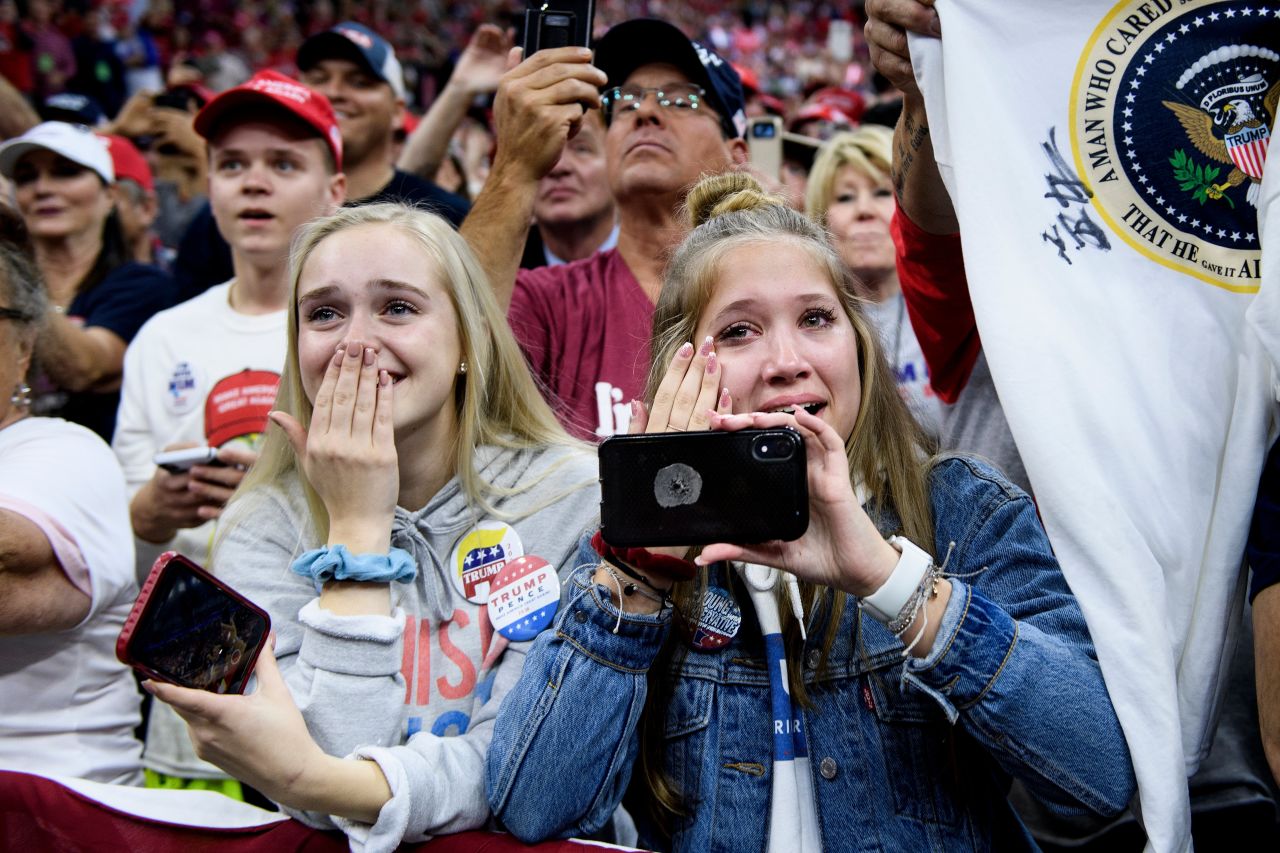 People watch as US President Donald Trump arrives for a campaign rally in Minneapolis on Thursday, October 10.
