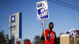 A member of the United Auto Workers walks the picket line at the General Motors Romulus Powertrain plant in Romulus, Mich., Wednesday, Oct. 9, 2019. Nearly four weeks into the United Auto Workers' strike against GM, employees are starting to feel the pinch of going without their regular paychecks. (AP Photo/Paul Sancya)