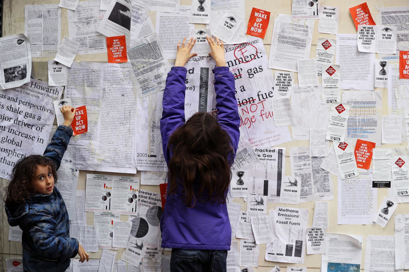 Oisin O'Connor and his sister, Eve, help wallpaper the front of the Department of Communications, Climate Action and Environment in Dublin, Ireland, on Friday, October 11.