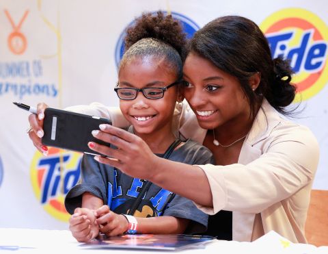 Biles takes a photo with a young fan in her hometown of Houston in September 2016.