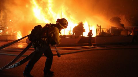 The Saddleridge fire flares up near a firefighter in Los Angeles' Porter Ranch neighborhood.