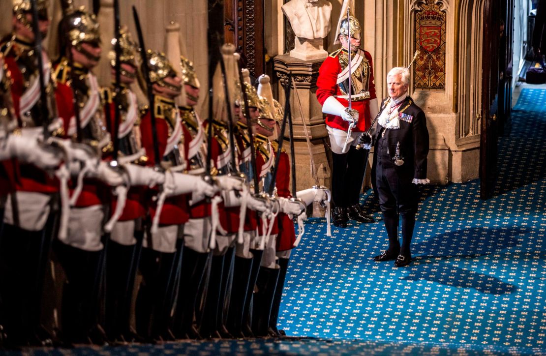 Black Rod waits at the bottom of the stairs before the arrival of Queen Elizabeth II.
