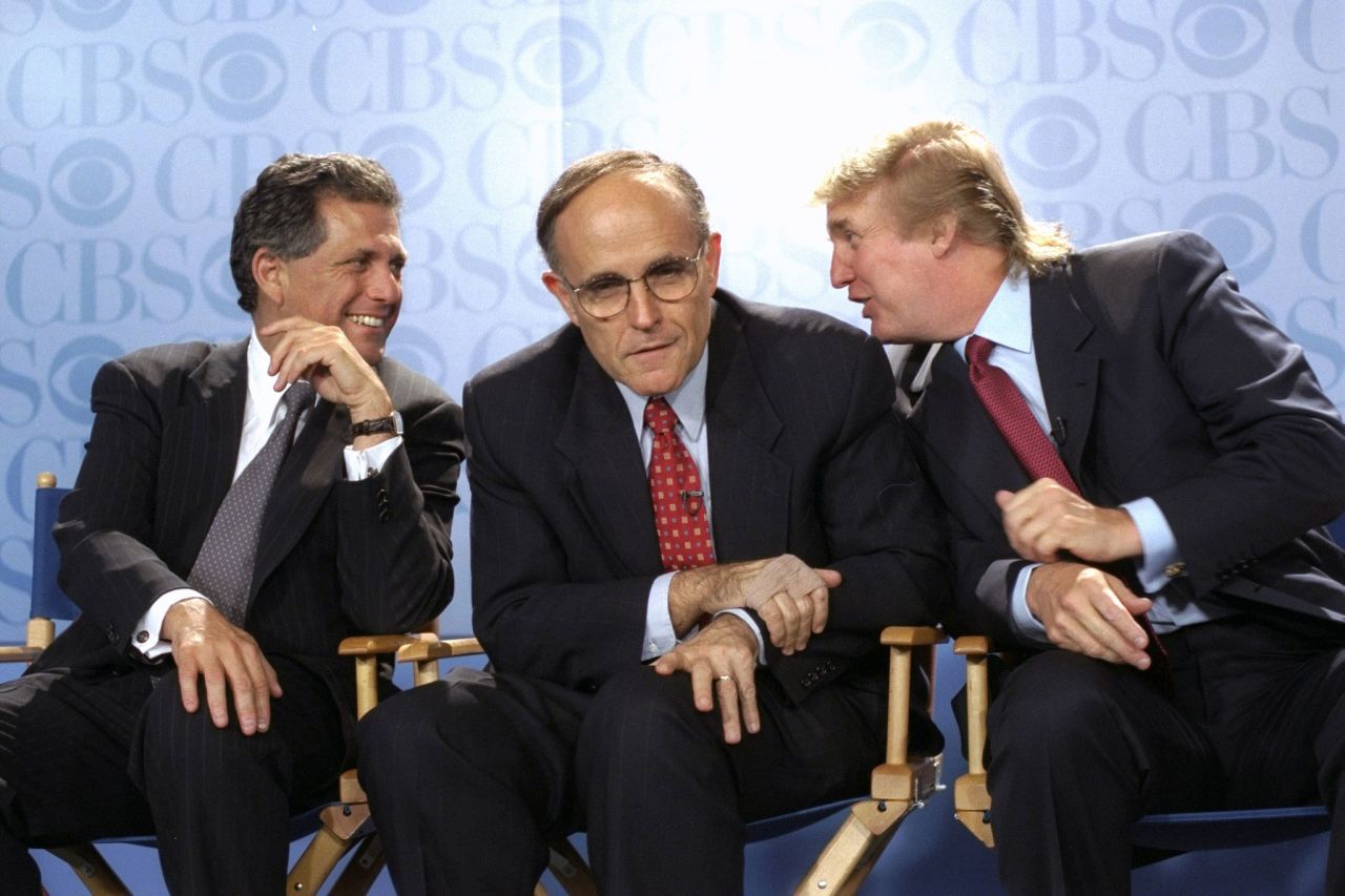 Giuliani is flanked by CBS President Les Moonves, left, and Donald Trump at a news conference in May 1999. CBS was announcing that Bryant Gumbel would be the host of a new morning news program that would air from Trump's International Plaza Building.
