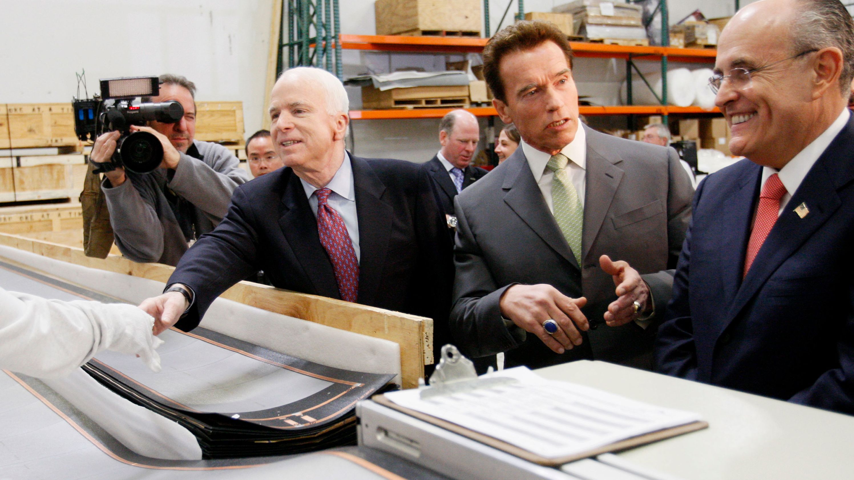 California Gov. Arnold Schwarzenegger talks to Giuliani as Giuliani and McCain tour a solar panel manufacturer in Los Angeles in January 2008.