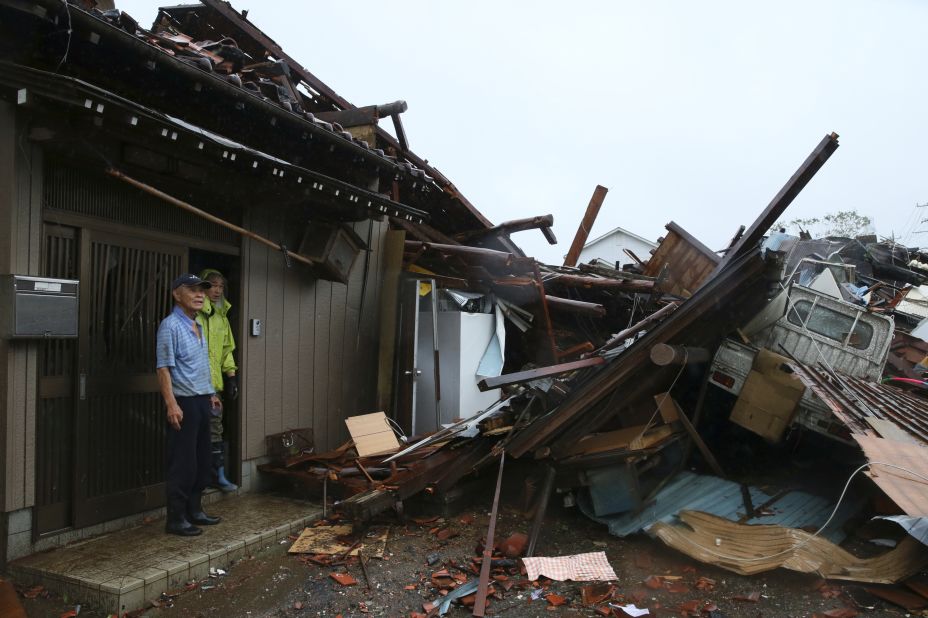 Residents survey damage caused by a suspected tornado in Ichihara, Japan, on October 12.