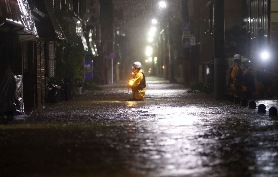 A rescue worker wades in floodwater in a residential area of Tokyo on October 12.