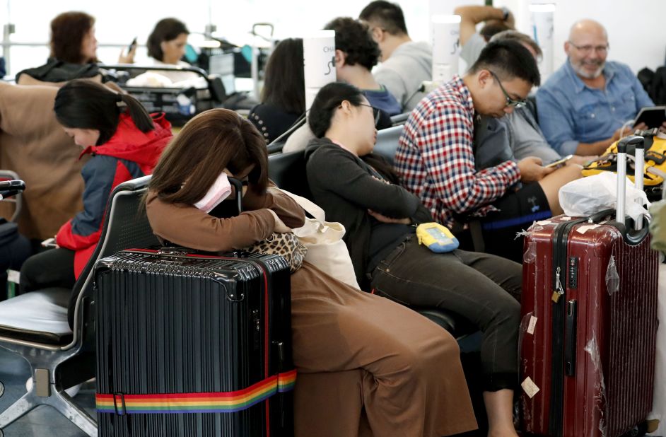 People sleep at the Haneda Airport in Tokyo on October 12. Flights were canceled on Saturday as Typhoon Hagibis approached the coast of Japan.
