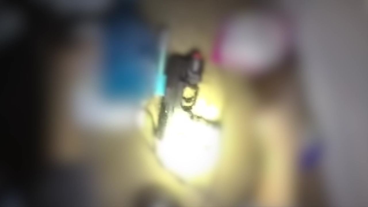 Body camera footage appears to show a firearm found inside the home. This image is part of heavily edited video released by police on Saturday. 