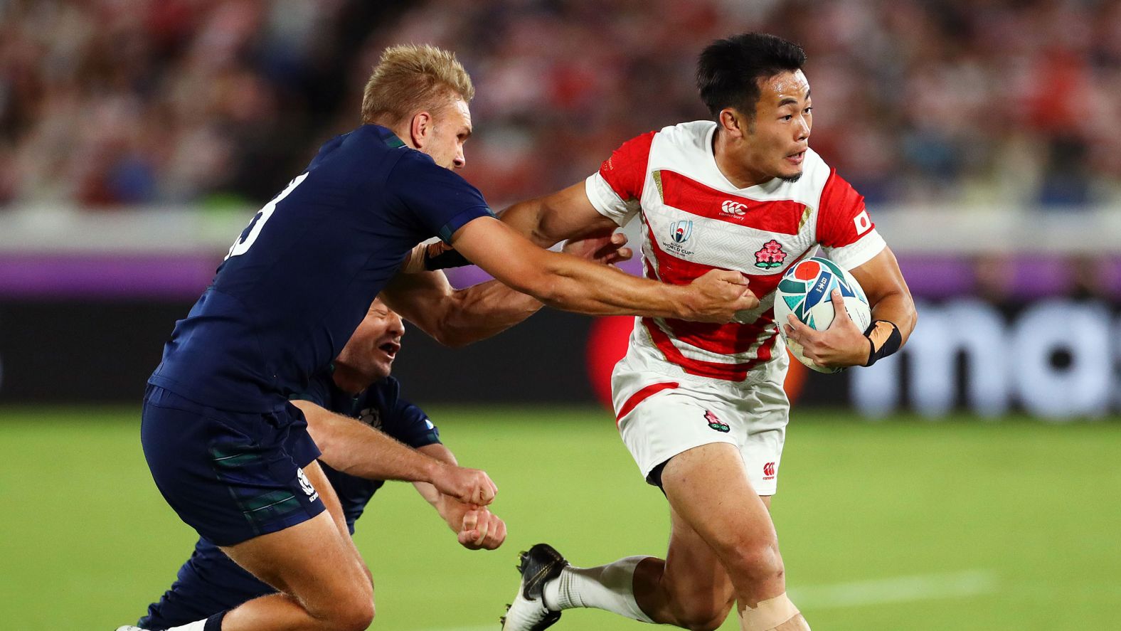 Japan's Kenki Fukuoka evades Scotland's Chris Harris and Greig Laidlaw during the Group A game between Japan and Scotland at International Stadium Yokohama in Yokohama, Japan, on Sunday.