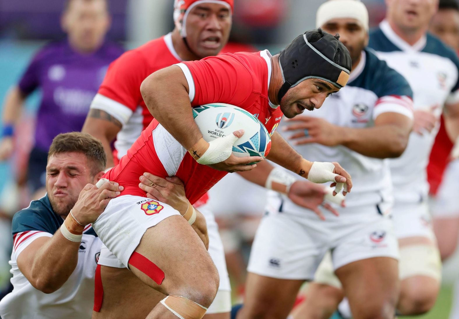 Tonga's Malietoa Hingano runs at the United States defense.