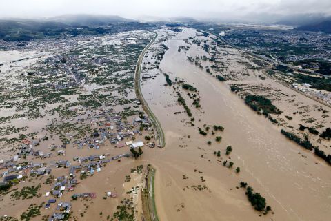 Residential areas are submerged in muddy waters after an embankment of the Chikuma River broke in Nagano, Japan, on Sunday, October 13. 