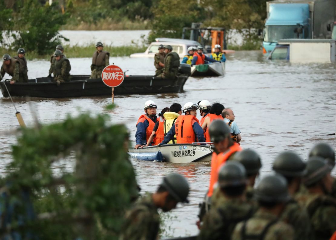 Fire department workers evacuate residents from a flooded area in Kawagoe, Saitama prefecture on October 13, 2019, one day after Typhoon Hagibis swept through central and eastern Japan. 