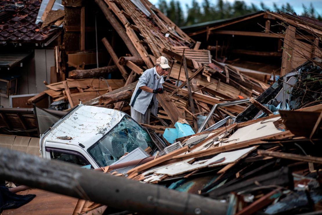 A man sorts through the debris of a building that was destroyed by a tornado shortly before the arrival of Typhoon Hagibis, on October 13, 2019 in Chiba, Japan.