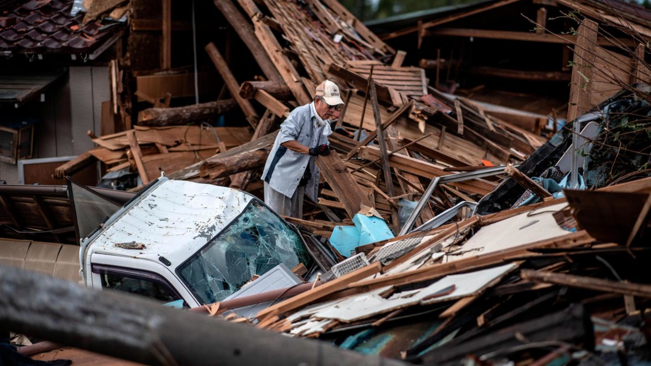 A man sorts through the debris of a building that was destroyed by a tornado shortly before the arrival of Typhoon Hagibis, on October 13, 2019 in Chiba, Japan.