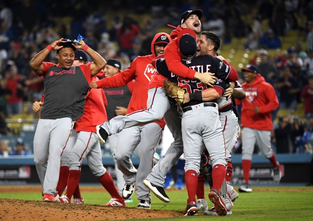 Washington Nationals teammates Daniel Hudson, Sean Doolittle and Yan Gomes celebrate defeating the Los Angeles Dodgers in extra innings during game five of the National League Division Series in Los Angeles, California, on Wednesday, October 9. The Nationals won the game 7-3 after Howie Kendrick hit a grand slam in the top of the 10th inning to put Washington ahead.