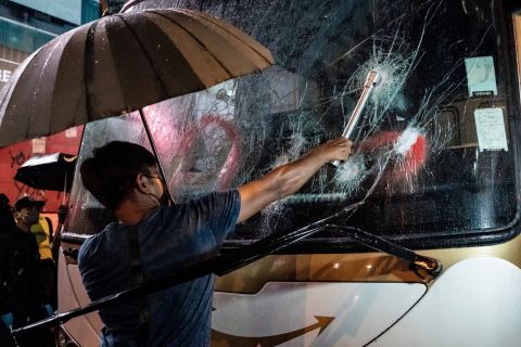 A protester attempts to break a tourist bus window on October 13.