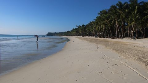 Residents walk along a beach on the Philippine island of Boracay.
