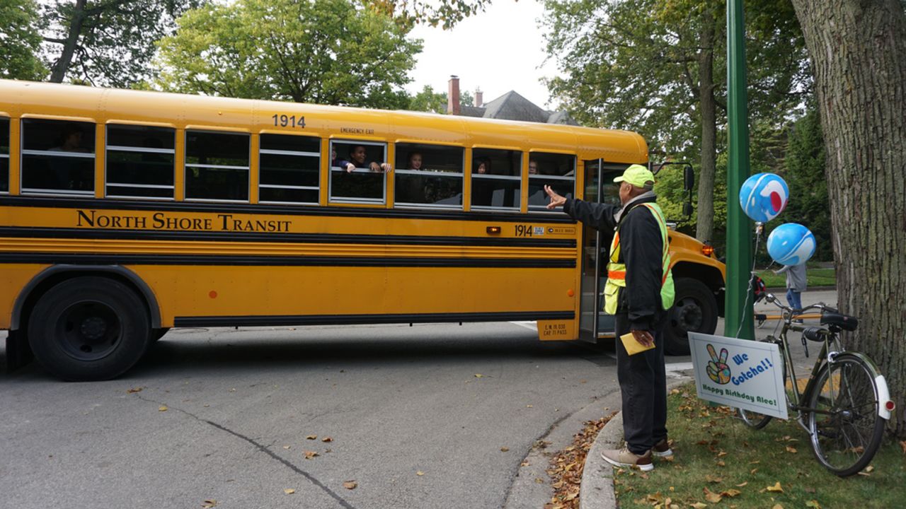 Alec Childress waves to kids on the school bus.