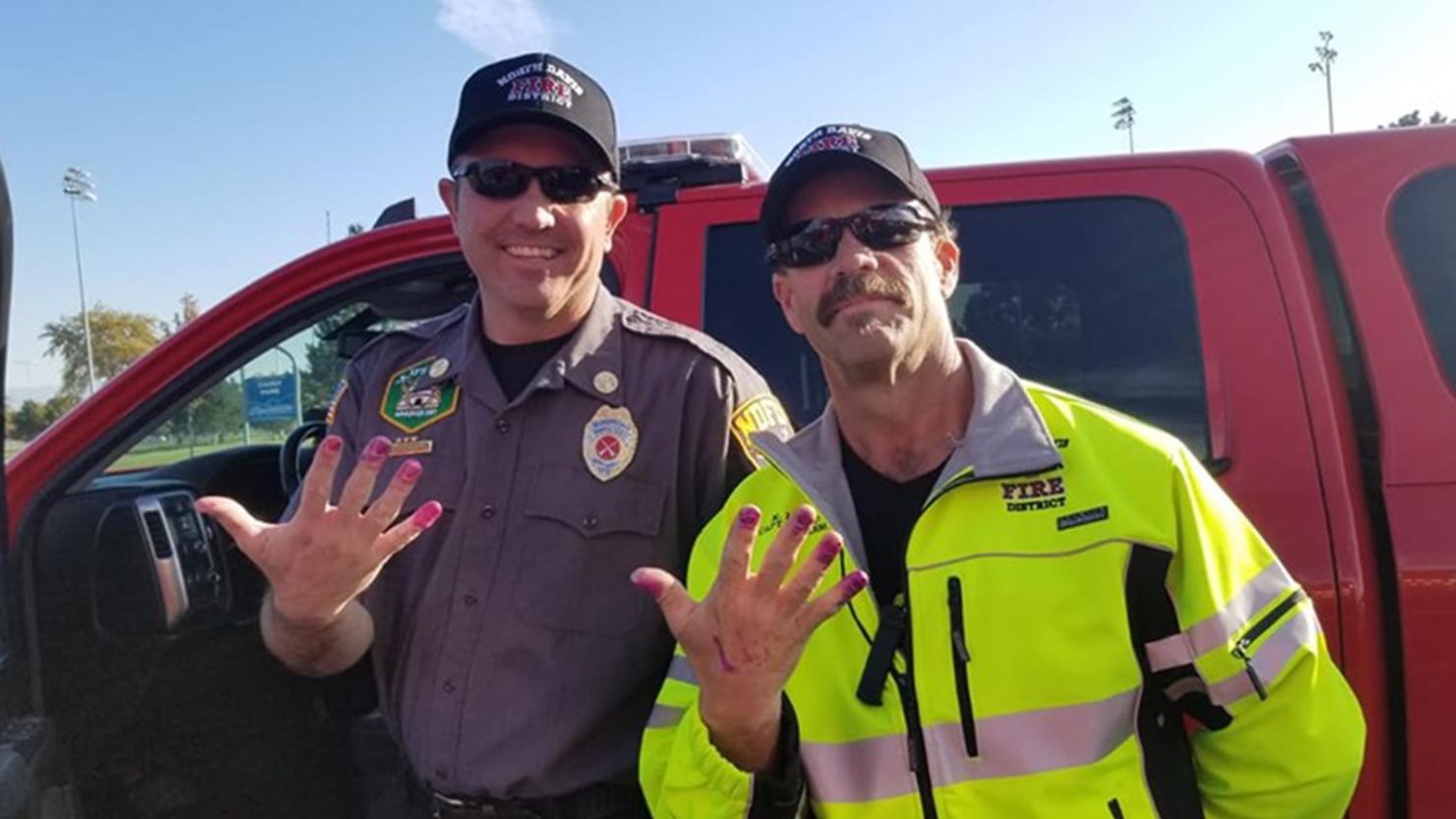Battalion Chief Allen Hadley and Capt. Kevin Lloyd with the North Davis Fire District show off their purple manicures after they helped calm a young girl.