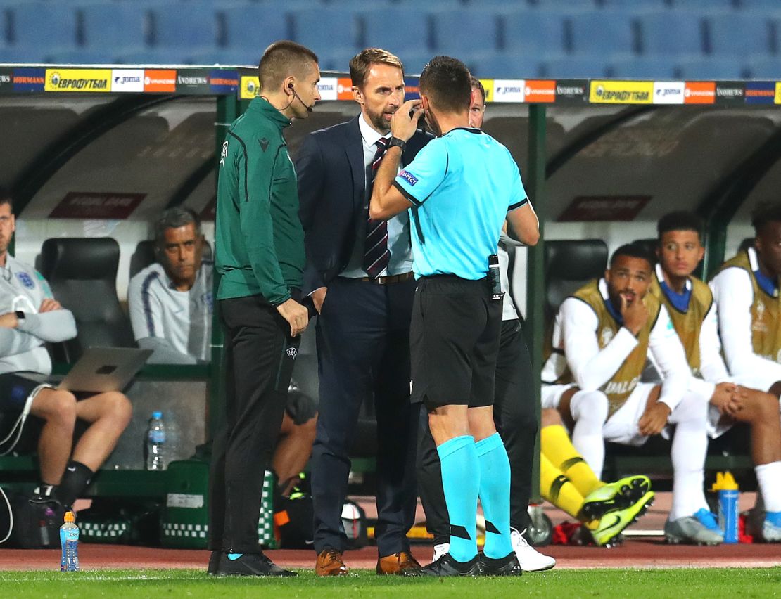 England manager Gareth Southgate speaks with the referee while the game is halted.