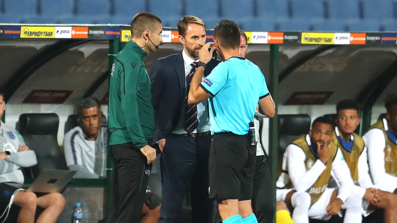 England manager Gareth Southgate speaks with the referee while the game is halted.