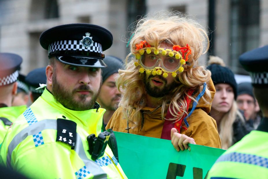 A protester stands near a policeman during a demonstration in London.
