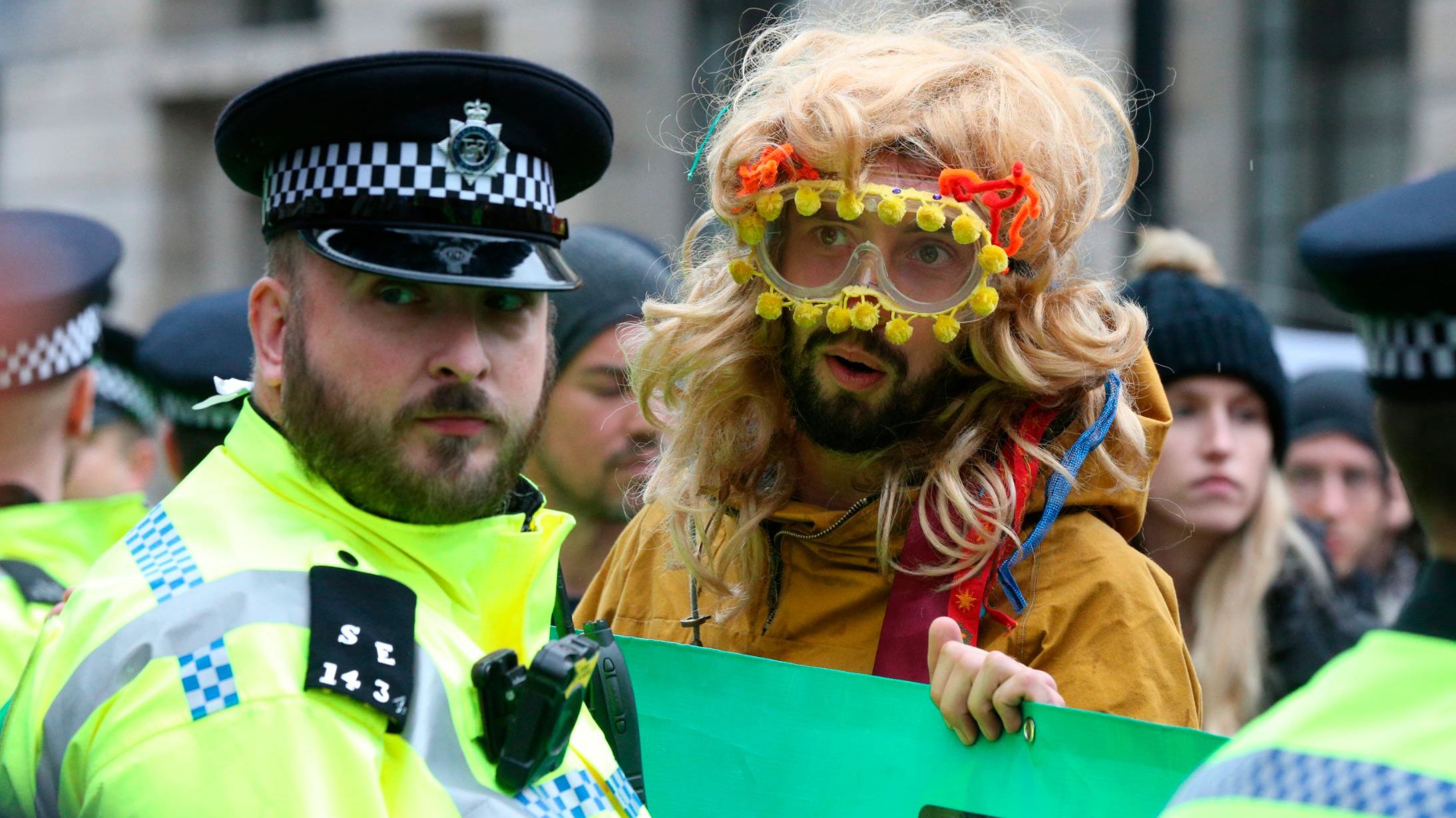 A protester stands near a policeman during a demonstration in London.
