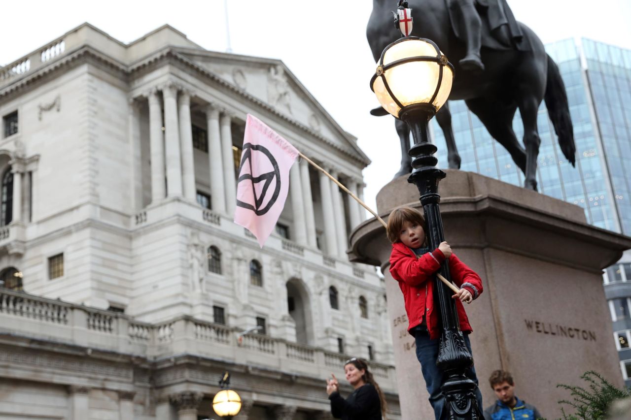 A young child waves an Extinction Rebellion flag outside of the Bank of England during the eighth day of demonstrations October 14.