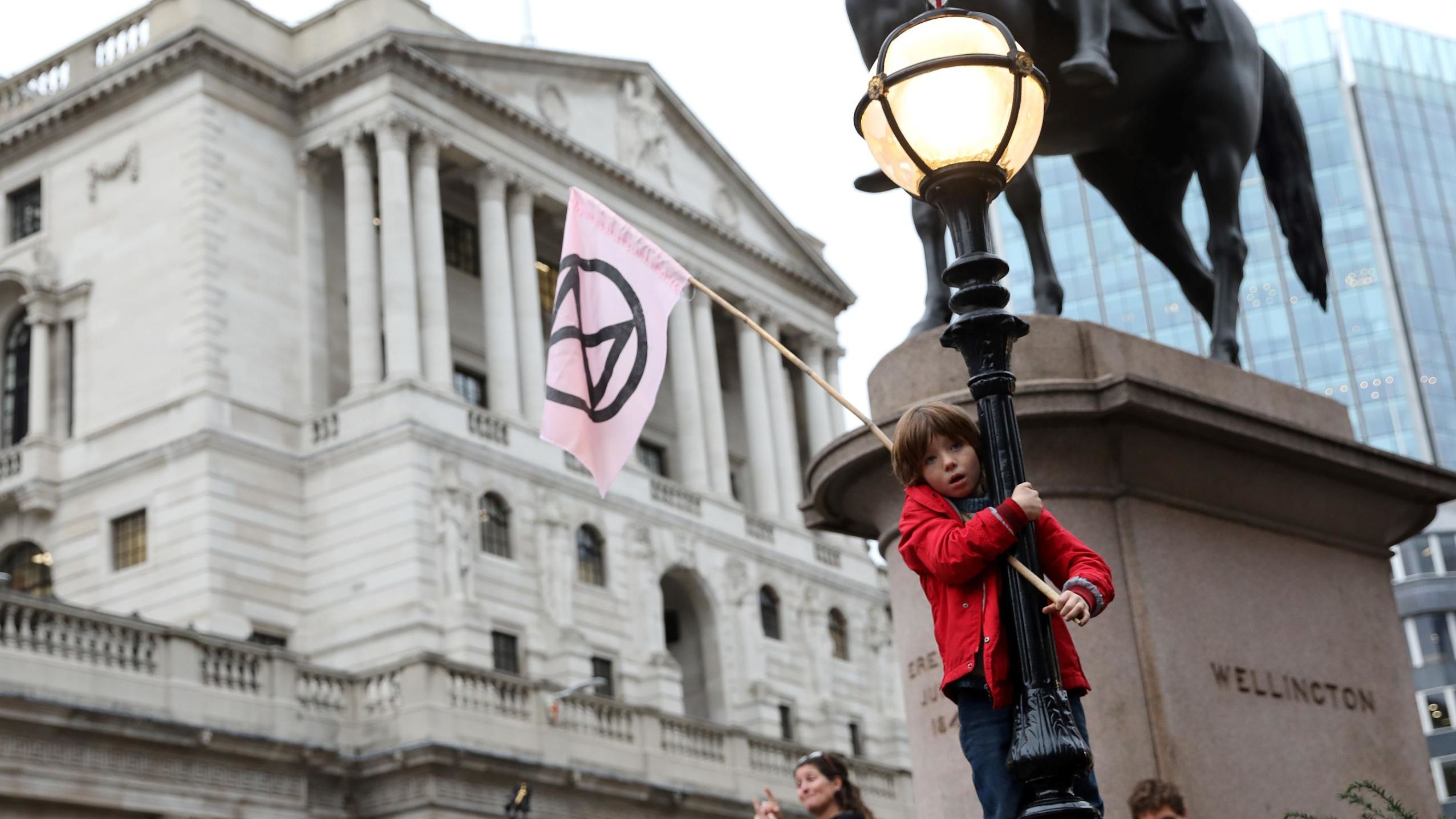 A young child waves an Extinction Rebellion flag outside of the Bank of England during the eighth day of demonstrations October 14.