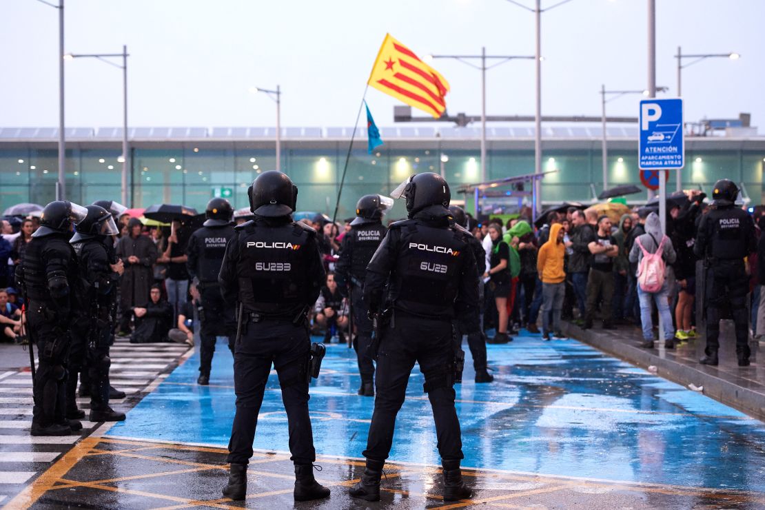 Police watch as protesters block access to Barcelona Airport on October 14. 