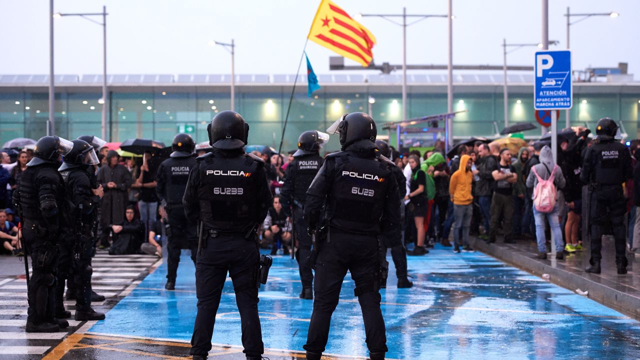Police watch as protesters block access to Barcelona Airport on October 14. 