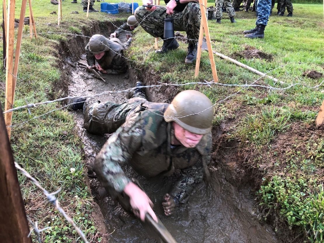 US Naval Academy plebes crawl under barbed wire and through mud during Sea Trials.