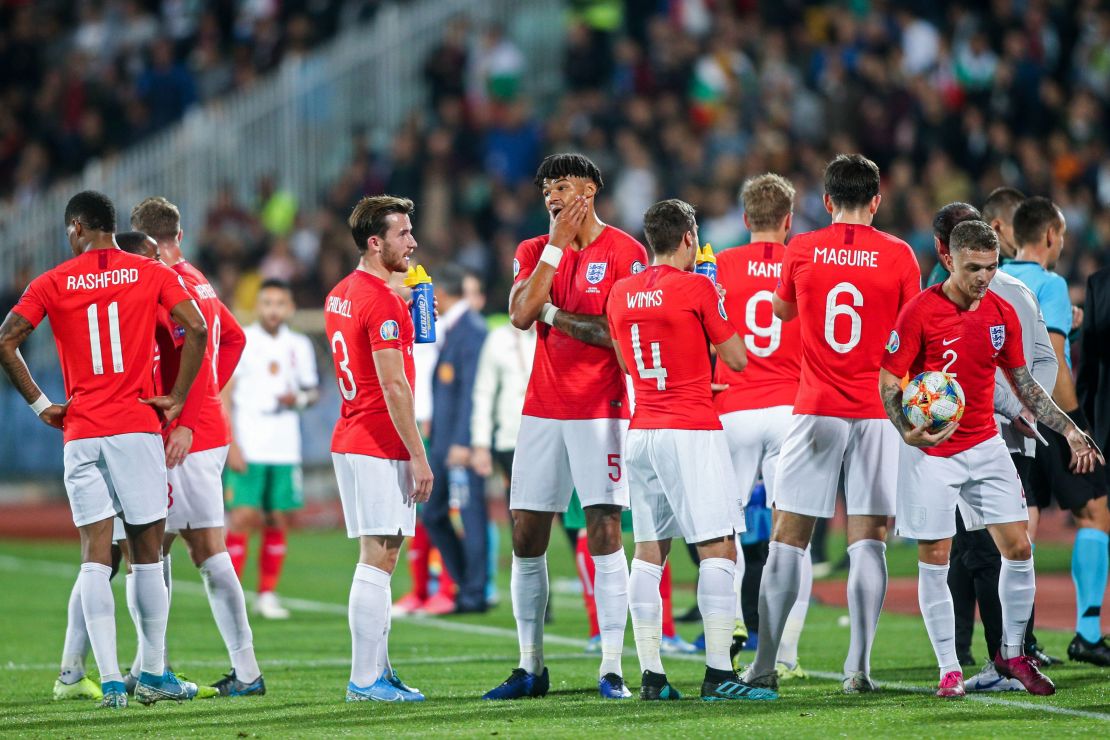 England's players wait on the pitch during a temporary interruption of the Euro 2020 game.