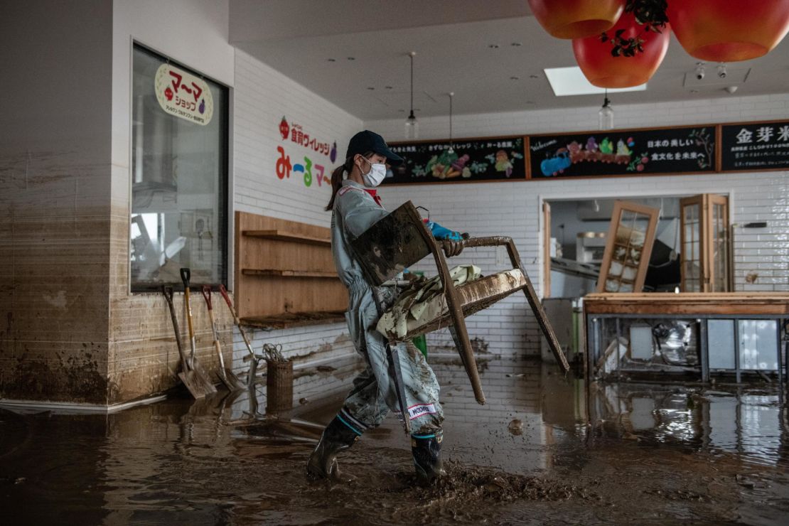 A woman helps to clear up a shop that was flooded during Typhoon Hagibis, on October 15, 2019 in Hoyasu near Nagano, Japan. 