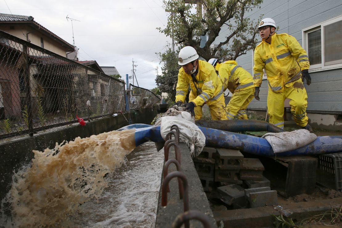 Firefighters pump water from a flooded area in the aftermath of Typhoon Hagibis in Nagano on October 15, 2019.