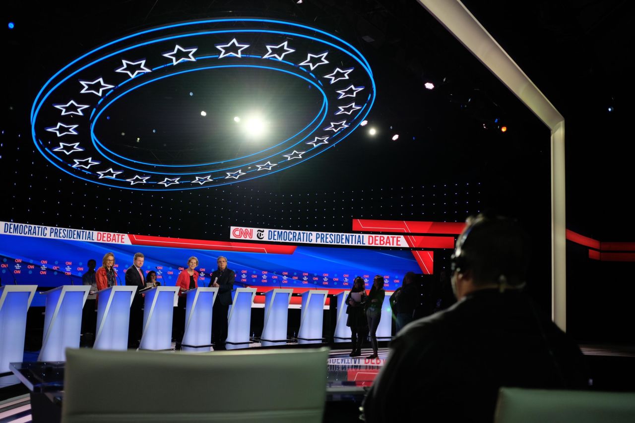 Warren stands by a lectern, third from left, during debate preparations on Tuesday.