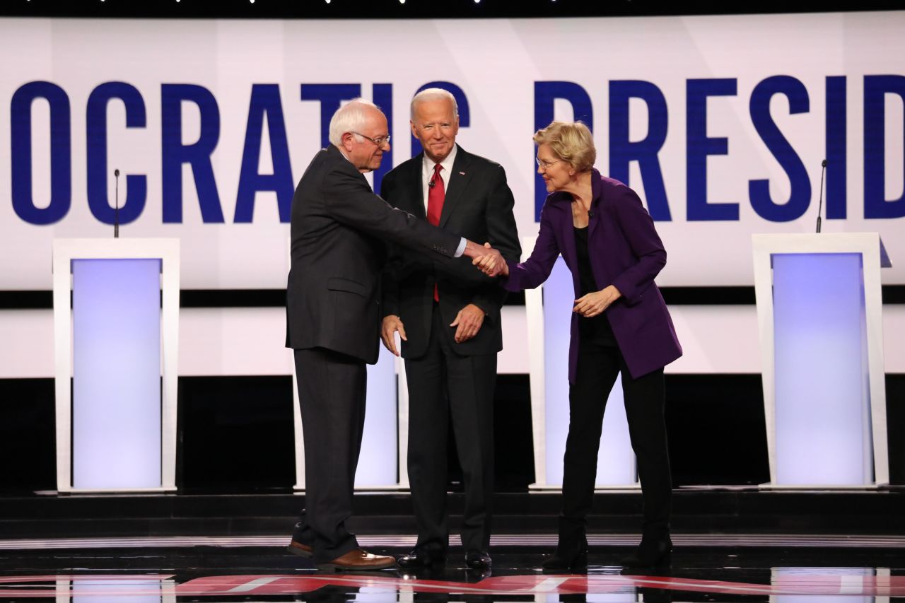 Sanders and Warren shake hands as the candidates are announced for the start of the debate.