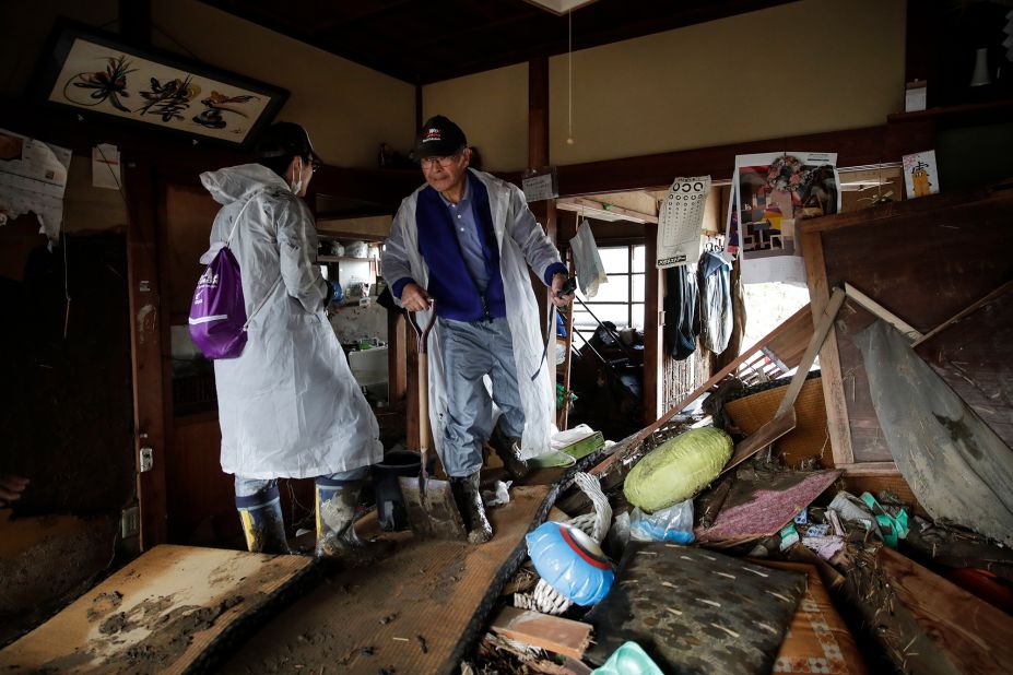Toshio Yonezawa, 73, center, surveys his home with son, Yusuke, after Typhoon Hagibis passed through his neighborhood Tuesday, October 15, in Nagano, Japan.