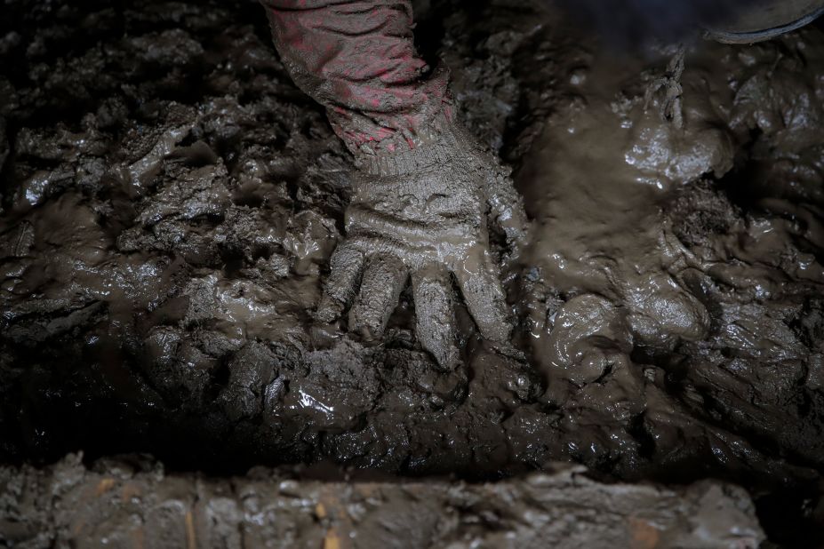 Yoshiki Yoshimura, 17, sifts through the mud for anything salvageable at his home destroyed by Typhoon Hagibis Tuesday.
