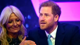 Prince Harry, Duke of Sussex reacts next to television presenter Gaby Roslin as he delivers a speech during the WellChild awards at Royal Lancaster Hotel on October 15, 2019 in London, England.