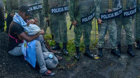 A migrant tends to a child while surrounded by members of the National Guard near Tuzantan, Mexico, on October 12.